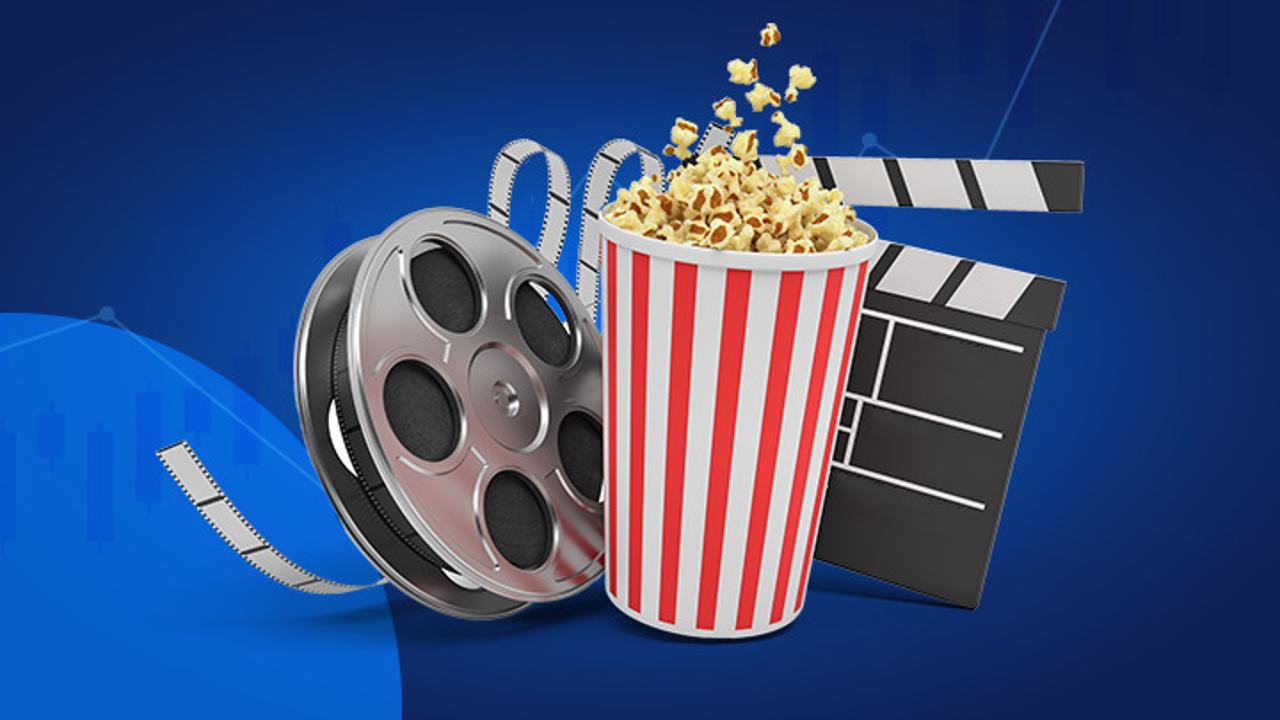 Mėlyname fone filmų kūrimo ir žiūrėjimo atributai – filmo juosta, kadrų skaičiuotuvas ir spragėsių indelis.
