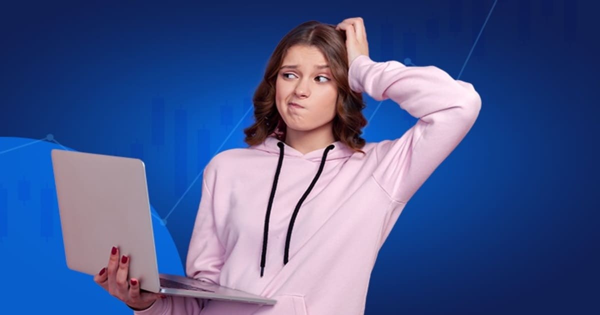 Jeune femme perplexe devant son ordinateur pour apprendre le trading sur fond de graphiques boursiers.