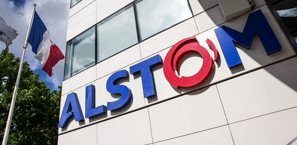 Voorgevel van Alstom kantoor met Alstom logo en Franse vlag, verwijzend naar beleggen het Alstom aandelen, spoorwegaandelen en de algehele transportsector.
