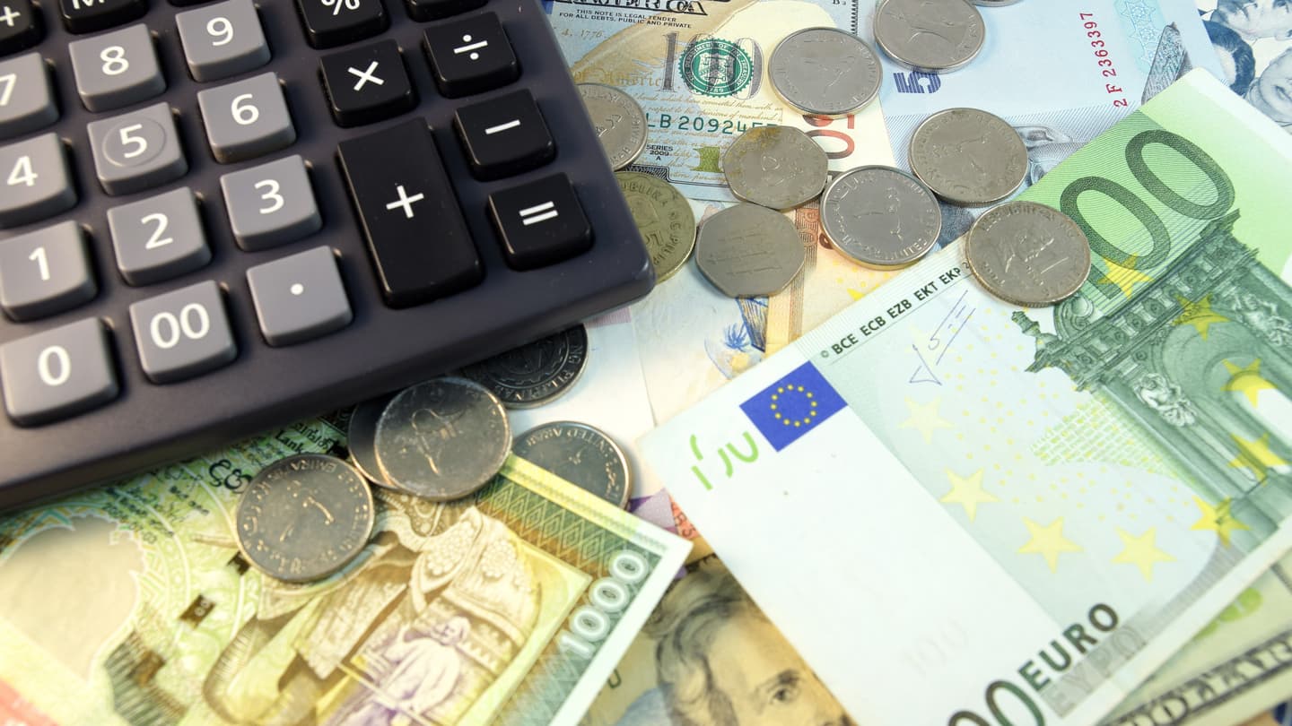 Vários tipos de dinheiro e uma calculadora explicando como funciona a calculadora forex