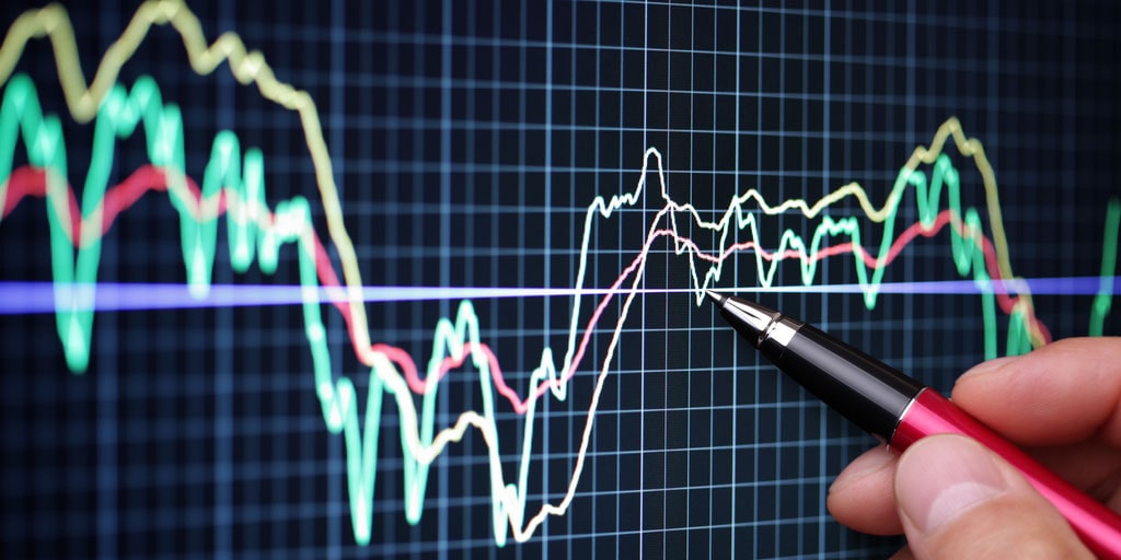 stylo posé sur un écran avec des graphiques de trading